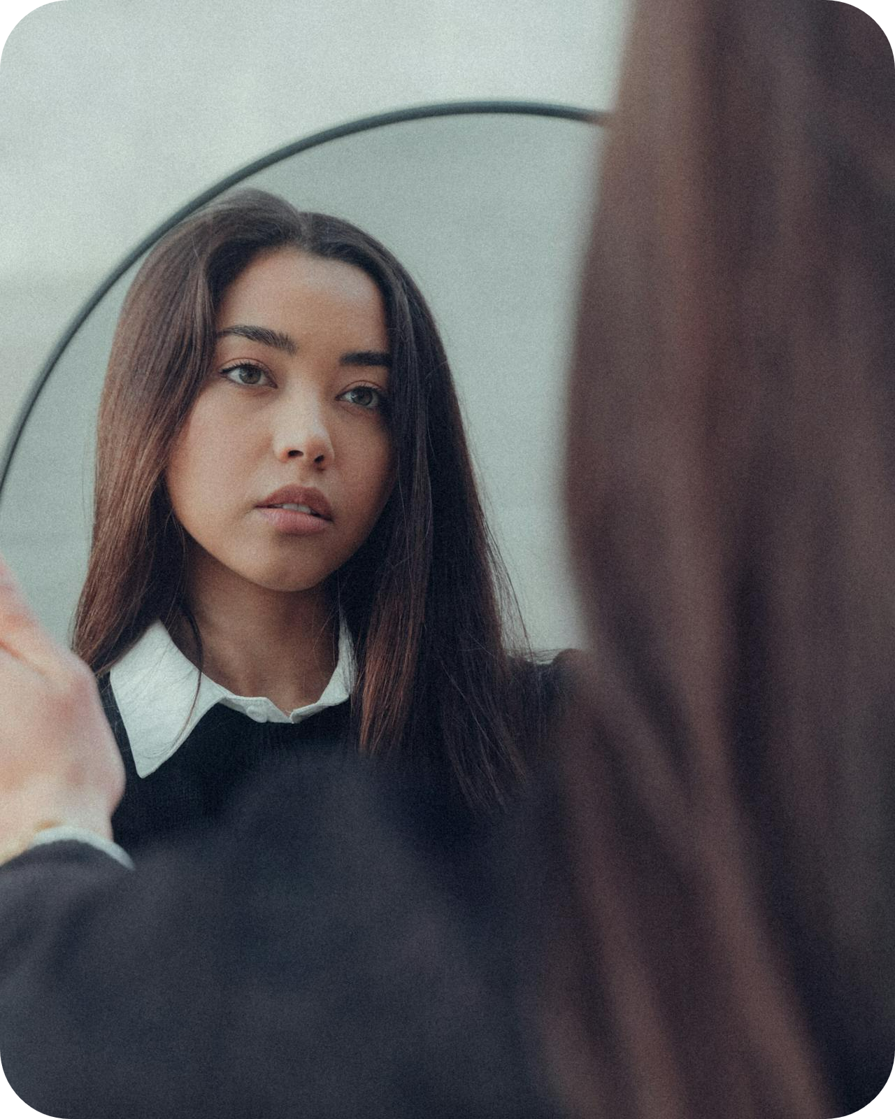 brunette young woman looking in mirror reflection of herself - how to get confidence to be a coach