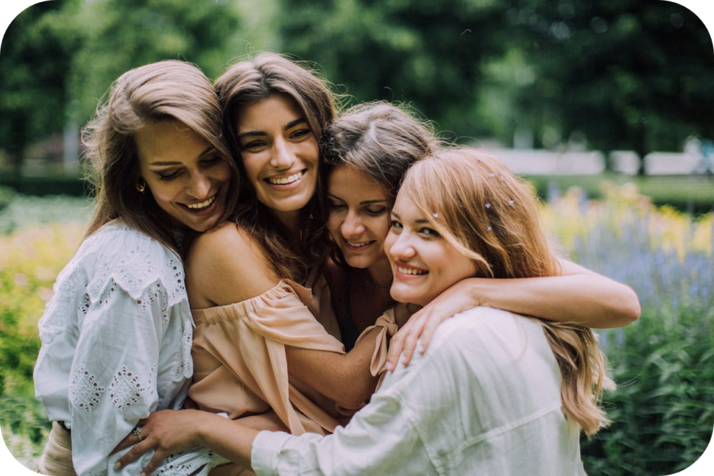 community of women smiling and hugging in nature scene - how to say you're a healer