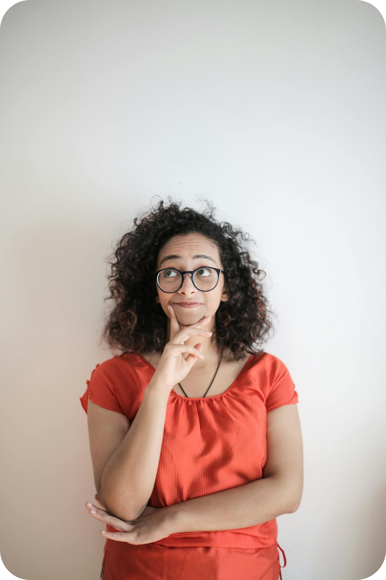 curly hair woman wearing glassed thinking - woman looking out window thinking - how to know what kind of coaching to do as a coach