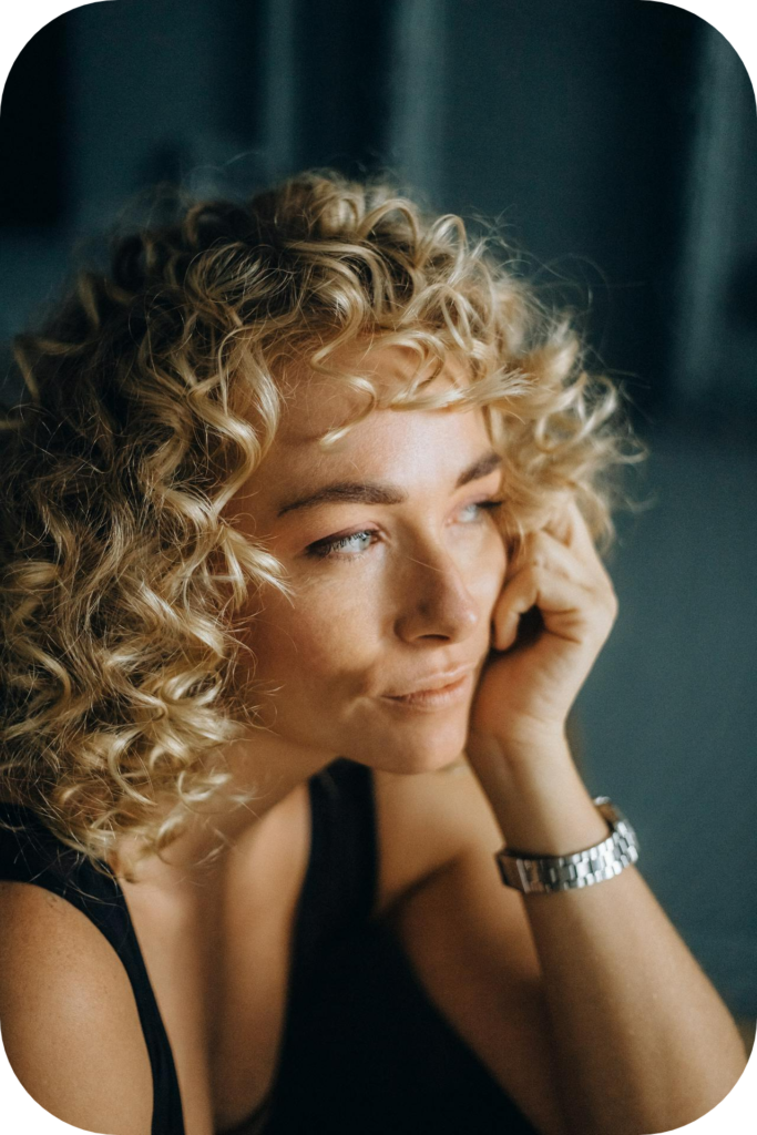 woman sitting by window thinking - gaining confidence to become a healer