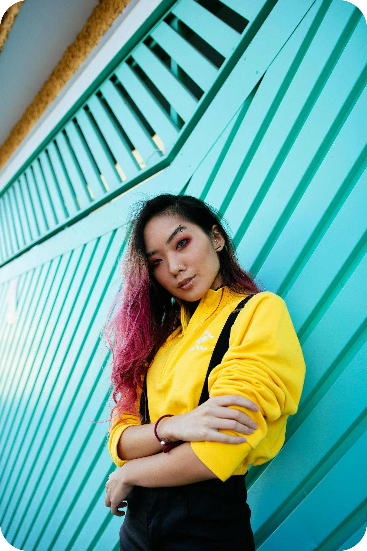 woman with pink hair and makeup wearing yellow top - build confidence as a coach